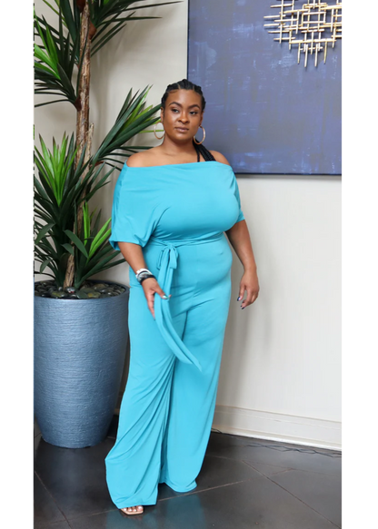 Stretchy off-shoulder jumpsuit with a belted waistline and wide legs. Model is 5'3, 205 lbs, wearing a size 1X.