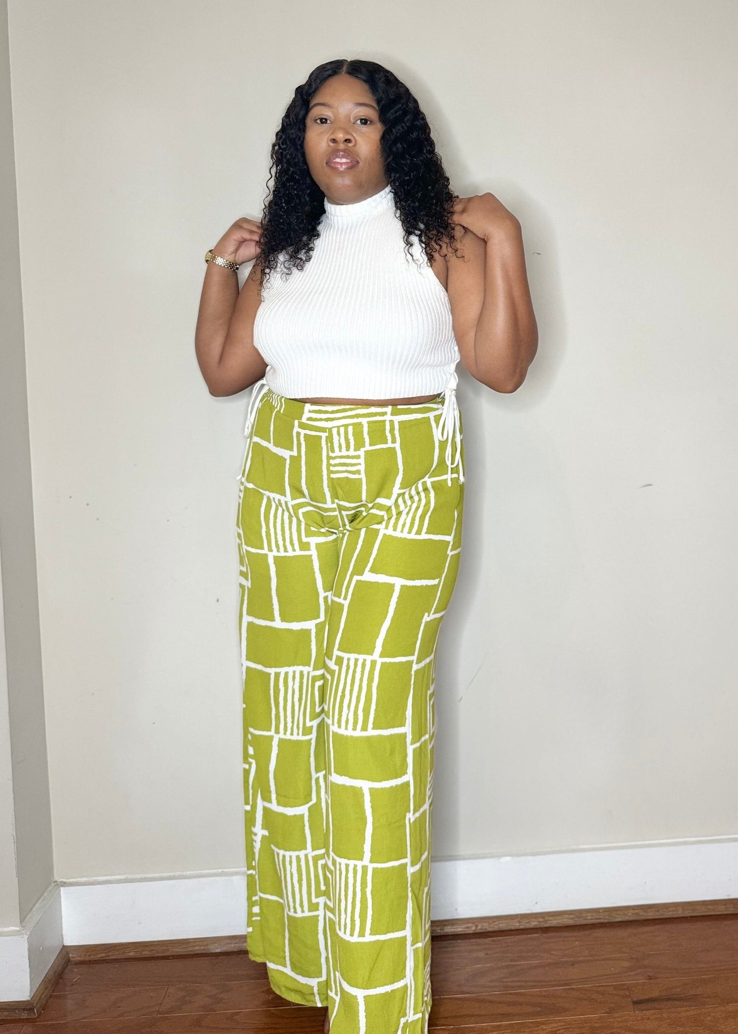 Bright green wide-legged pants with a slim waist and side pockets. Model is 5'2, 150 lbs, wearing a size Medium.