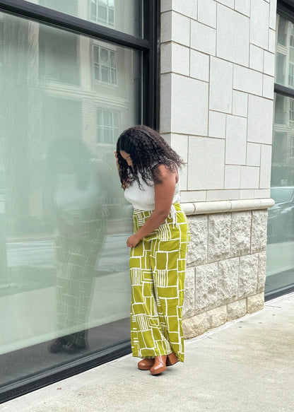 Bright green wide-legged pants with a slim waist and side pockets. Model is 5'2, 150 lbs, wearing a size Medium.