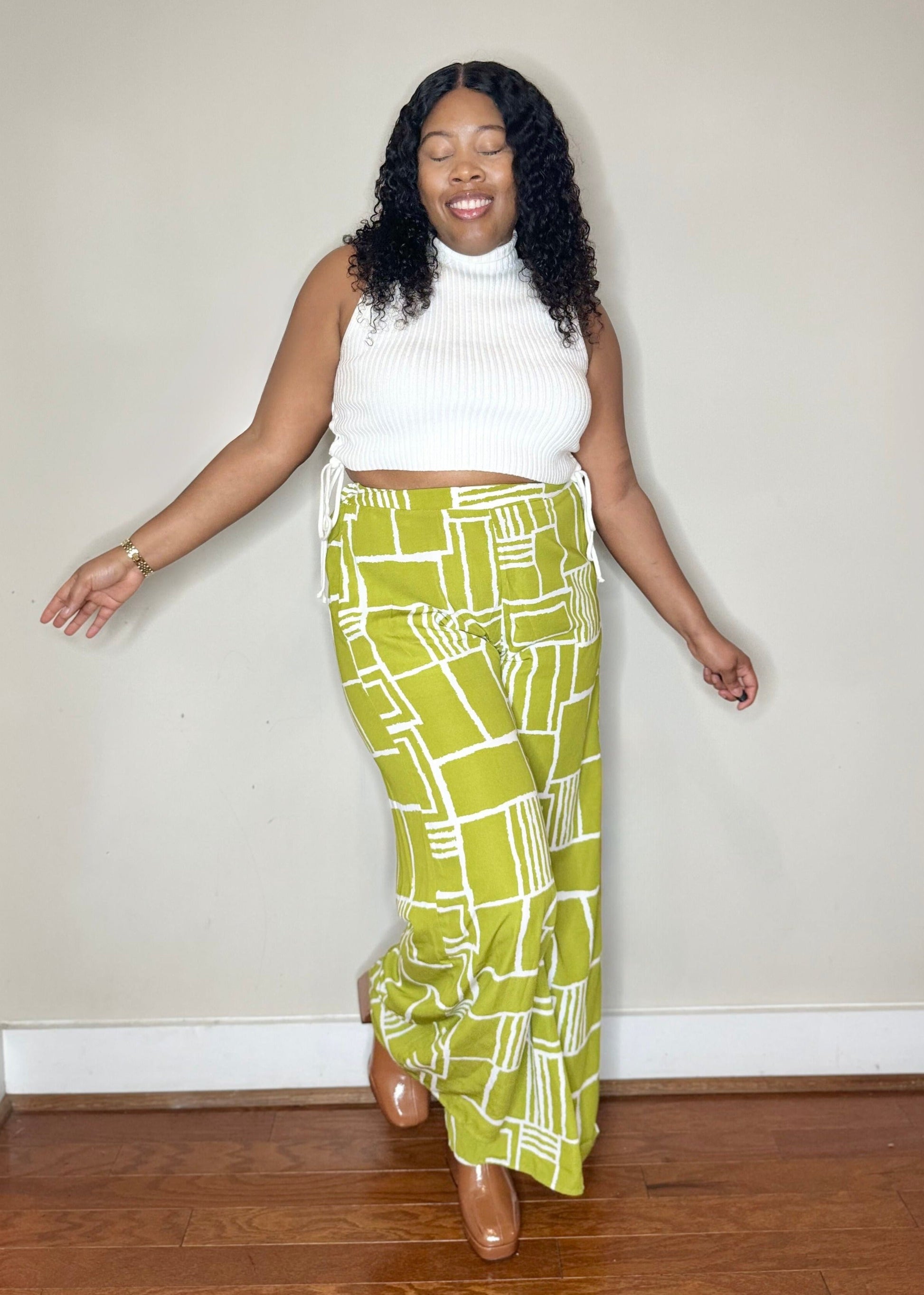 Bright green wide-legged pants with a slim waist and side pockets. Model is 5'2, 150 lbs, wearing a size Medium.